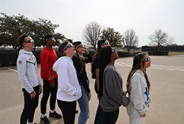  Students look up with eclipse glasses on
